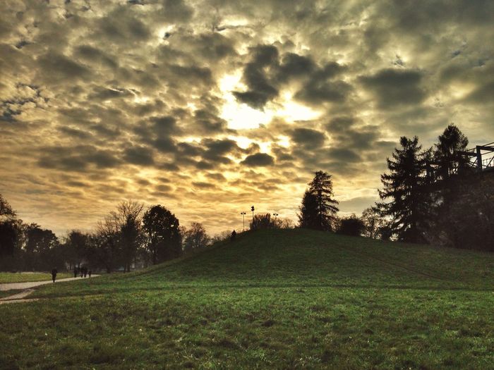 Scenic view of grassy field against cloudy sky