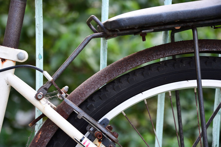 Close-up of rusty bicycle wheel on field