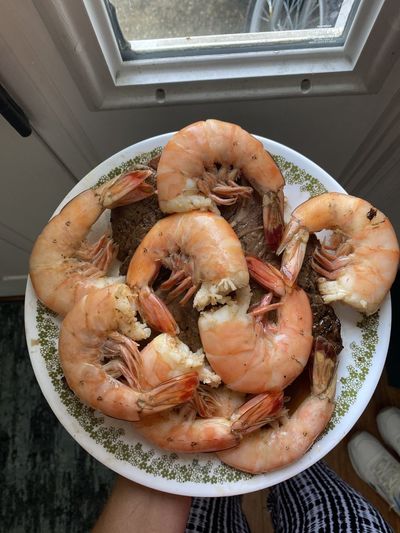 High angle view of hand holding prawns