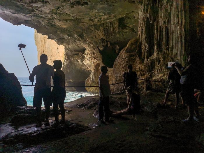 People standing on rock in cave