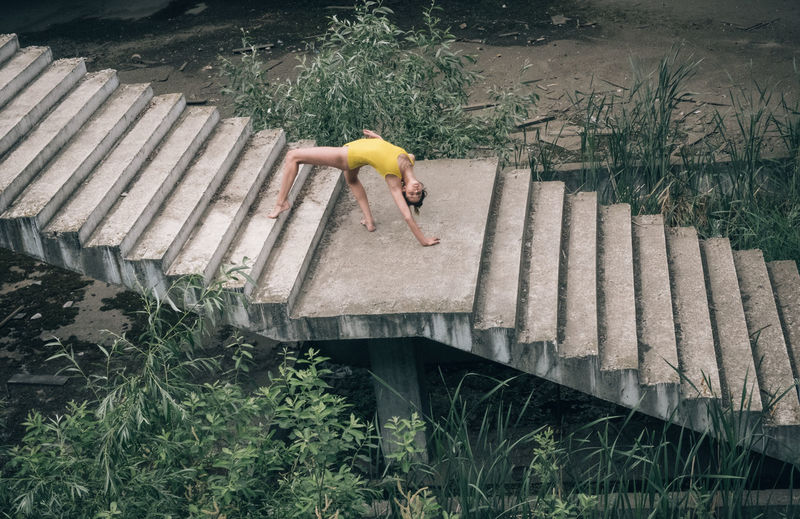 High angle view of young woman exercising on steps