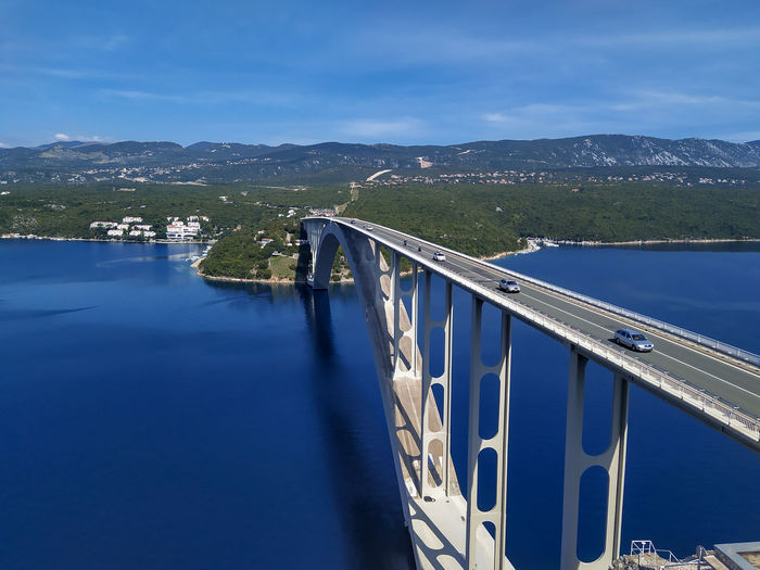 Bridge over lake against blue sky