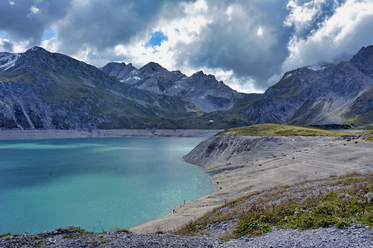 Scenic view of lake by mountains against sky