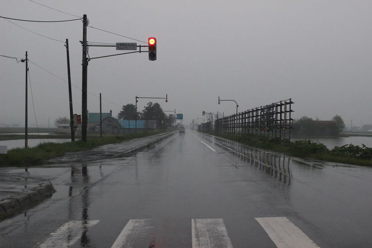 Road by city against sky during rainy season