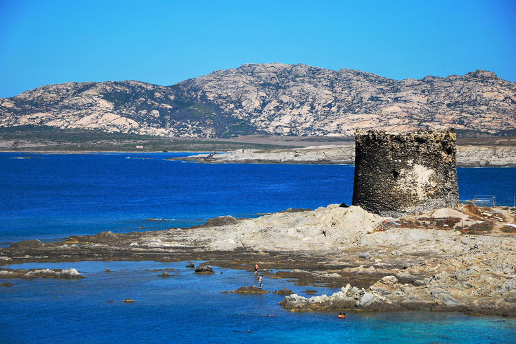 Scenic view of beach against clear blue sky