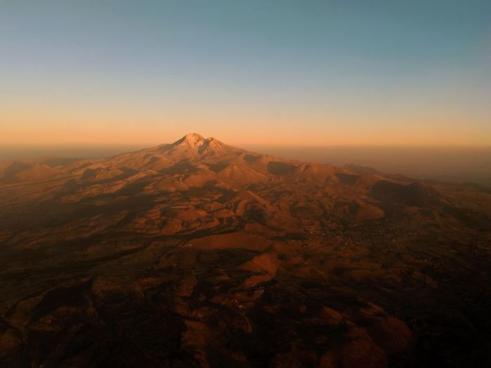 Scenic view of mountains against clear sky during sunset