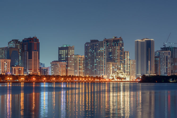 The tallest towers in the emirates and their reflection on the lakes at night, dubai, sharjah