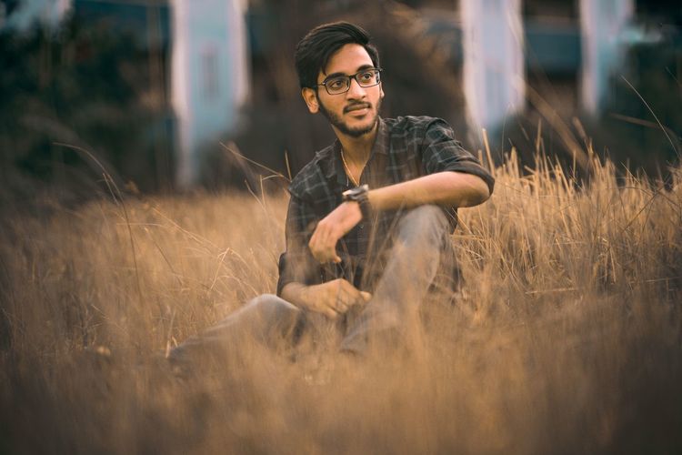 Young man looking away on field