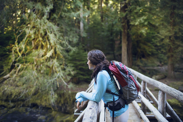 Young woman leaning on wooden bridge