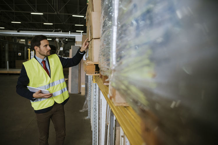 Man in warehouse supervising stock