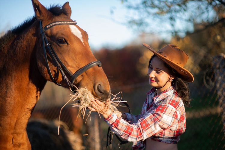 Woman feeding horse at ranch