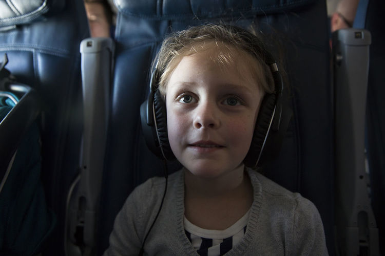 High angle view of girl listening music while in airplane