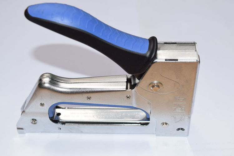 High angle view of staple gun on white background