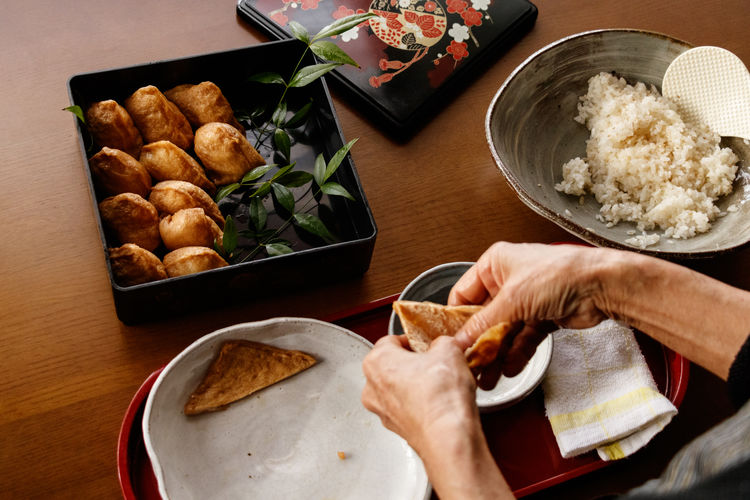 Cropped hand of person preparing food on table.
