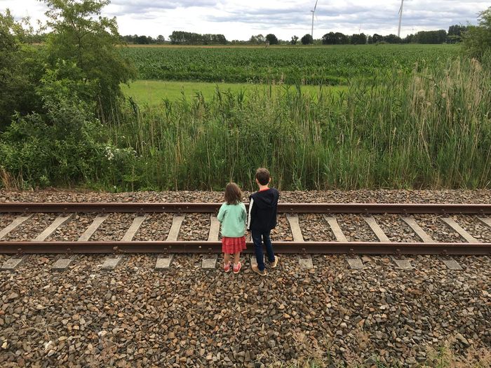 Rear view of friends on railroad track