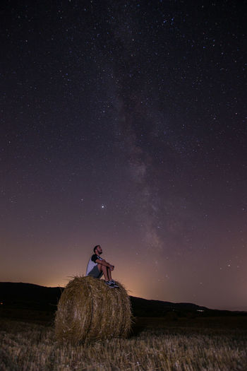 Man standing on field against sky at night with milky way