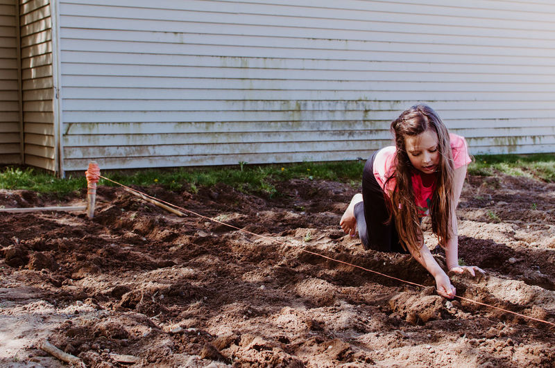 Full length of woman digging mud