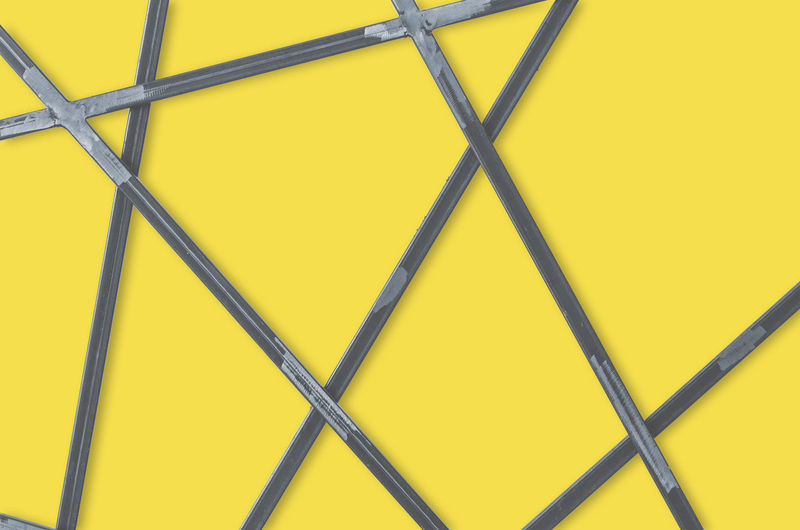 Metal geometric grid on yellow background. abstract steel bars backdrop. 