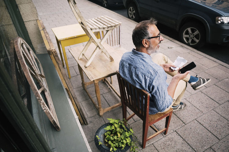 Man using mobile phone while sitting outdoors