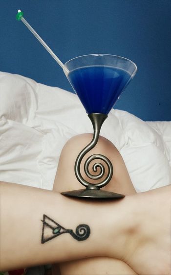 Midsection of tattooed woman with martini glass
