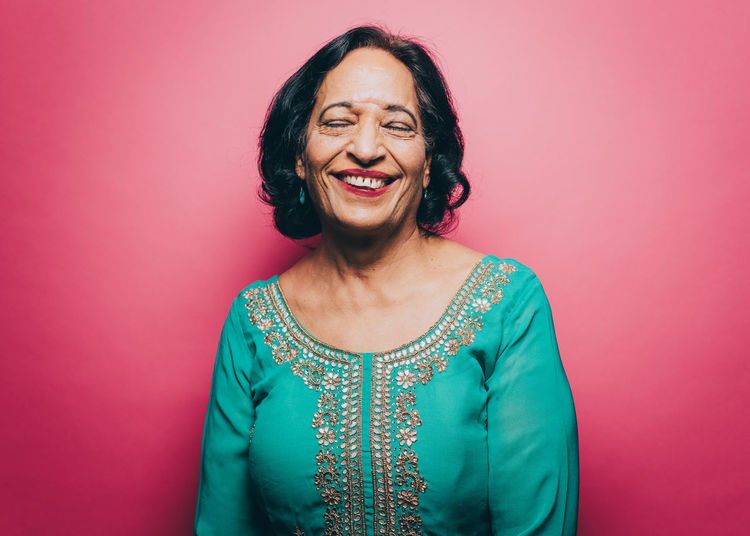 Portrait of smiling woman against red background