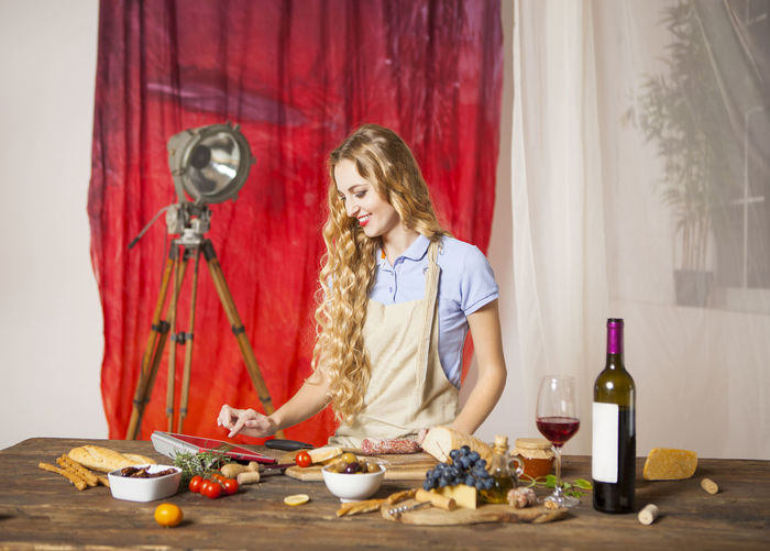 Young woman using digital tablet by food on table