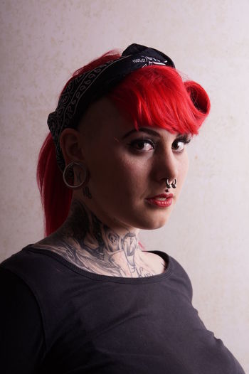 Close-up portrait of punk young woman by wall
