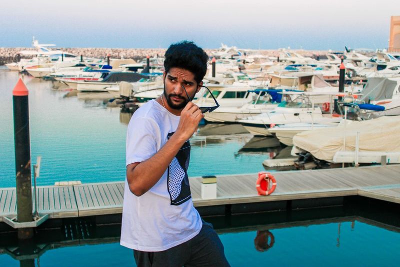 Portrait of young man standing on boat