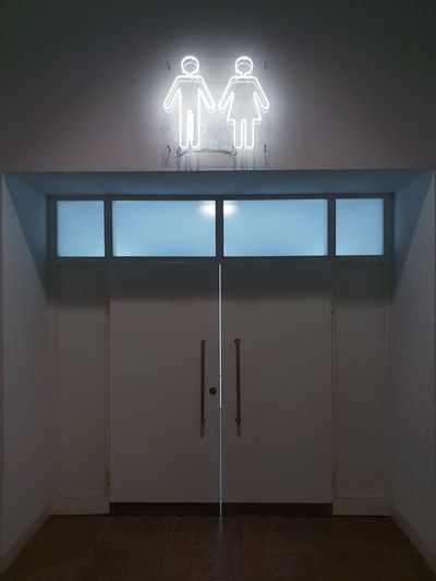 Low angle view of illuminated sign on wall