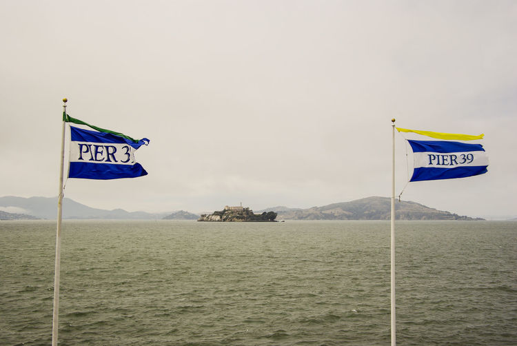 Flags waving against sea