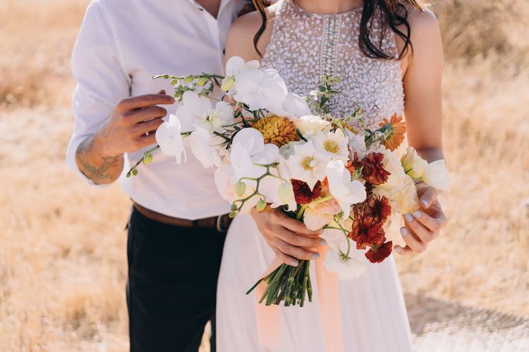 Midsection of woman holding bouquet 