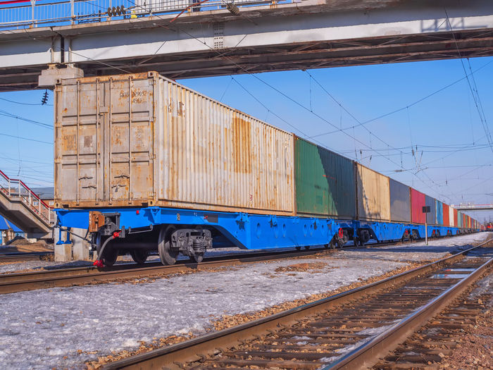 Long freight train of idler flat cars loaded with intermodal 40ft containers on the marshalling yard
