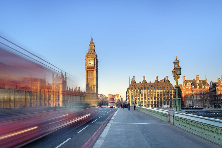 Double-decker bus passes on westminster bridge, in front of westminster palace and clock tower of big ben (elizabeth tower), london, england, united kingdom