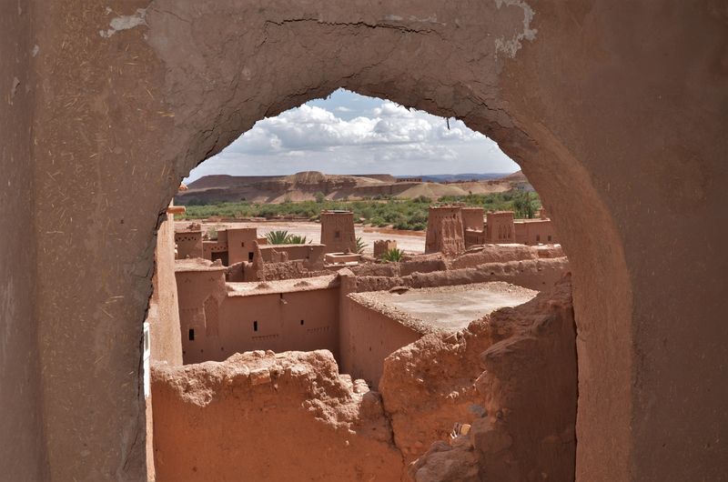 Scenic view of the kasbah ait ben haddou from a stone arch, morocco. 
 
invia 