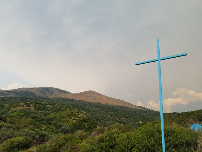 Cross on landscape against sky