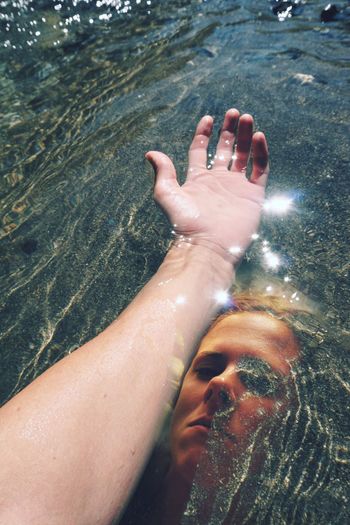 Double exposure portrait of woman and hand in water