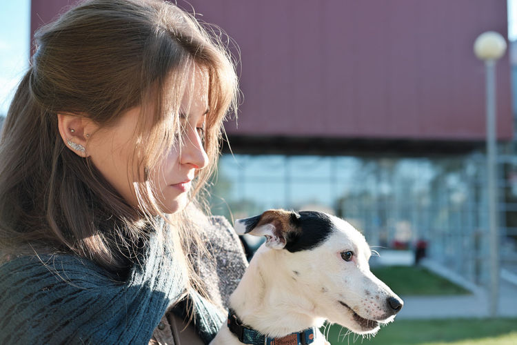 Woman with dog looking away outdoors