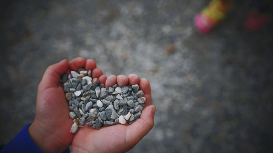 Close-up of hand holding pebbles
