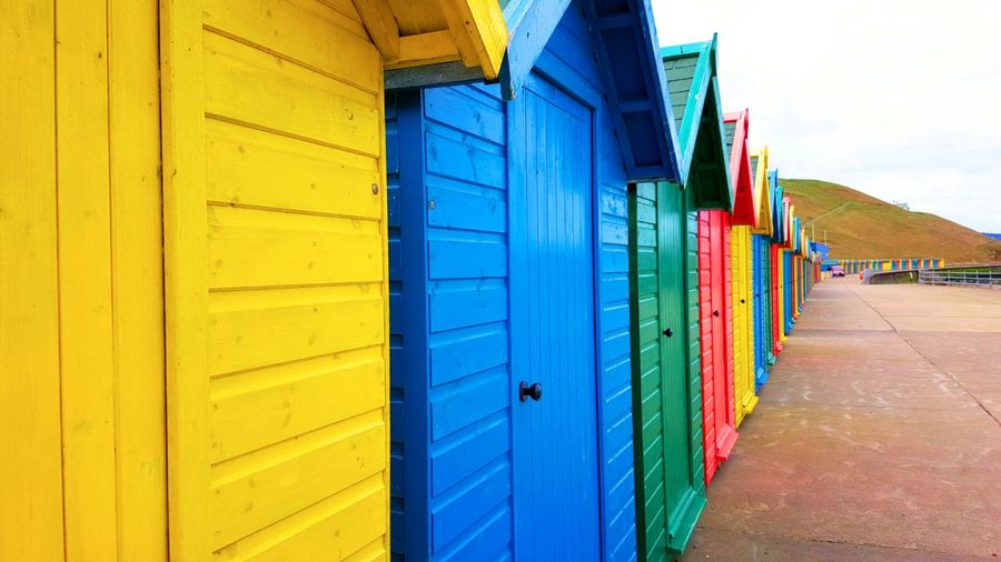 Multi colored beach huts on shore