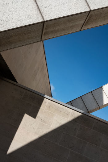 Minimalist photo of geometric shadows and  shapes created by sunlight and parts of a building. 