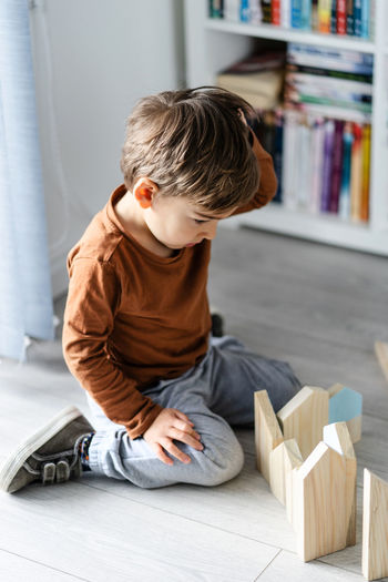 High angle view of boy sitting on floor at home