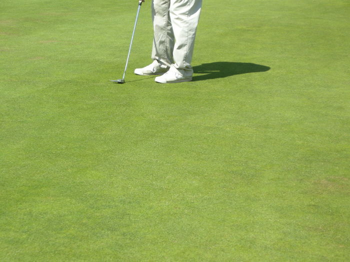 Low section of man playing golf on field