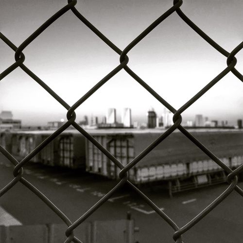 Cityscape seen through chainlink fence