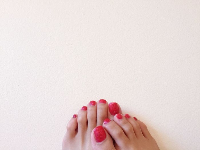 Low section of woman with red nail polish