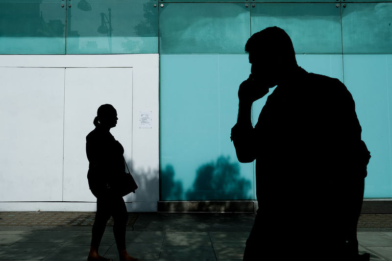 Silhouette people walking on street