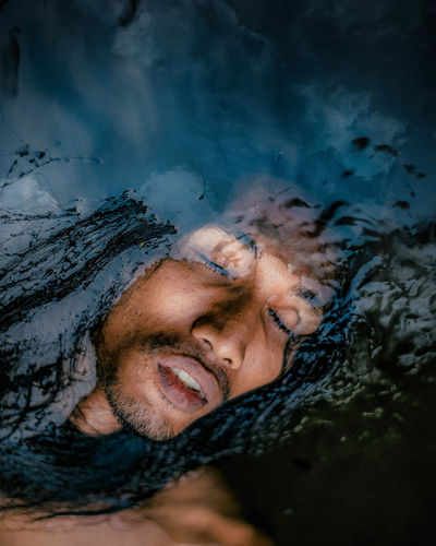 Portrait of young man with reflection in water