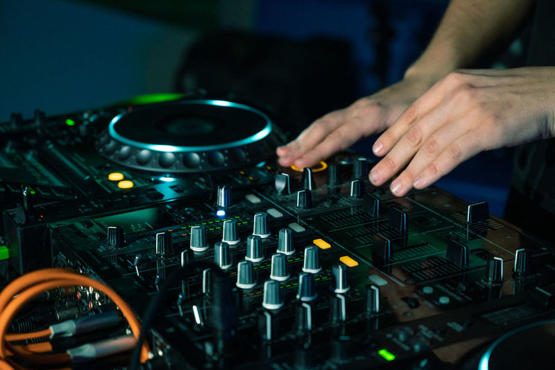 Cropped hand of dj playing music