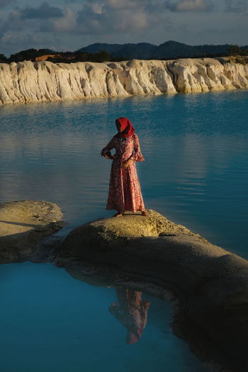 Woman standing on rock by lake