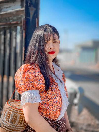 Woman looking away while standing outdoors