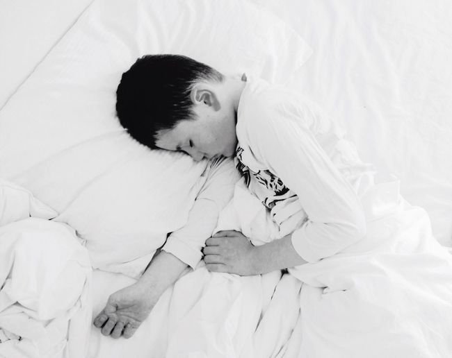 High angle view of boy sleeping on bed at home